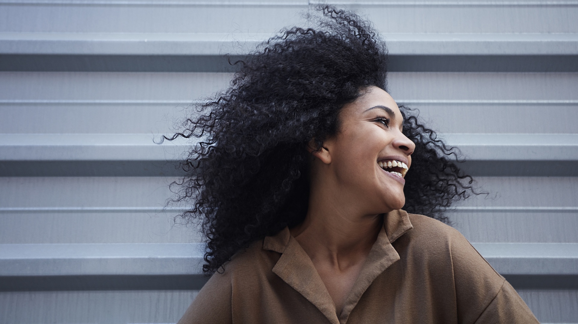 young-black-woman-with-afro-hair-laughing-enjoying